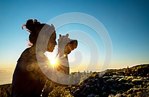 Silhouette of woman with camera. Woman takes photo of La Gomera Island in the rays of the setting sun. Tenerife Island