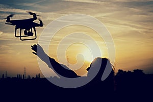 Silhouette of a woman catching a drone photo