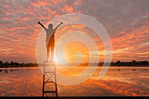 Silhouette of Woman Celebration Success Happiness Evening Sky Sunset at Lake Background, Sport and active life Concept