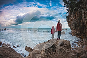 Silhouette of a woman and a child against the sea and sky