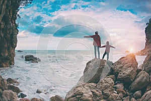 Silhouette of a woman and a child against the sea and sky