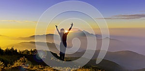 Silhouette of woman climb a peak of mountain hill at sunrise. Girl silhouette raise hand when trek on top mountain at sunset show