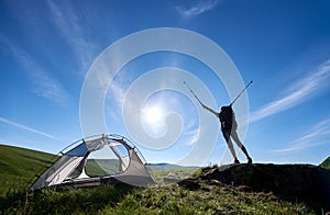 Silhouette of woman climber near camping against blue sky in the morning