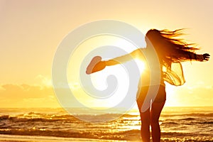 Silhouette of a woman dancing by the ocean