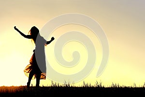 Silhouette of Woman Dancing and Praising God at Sunset