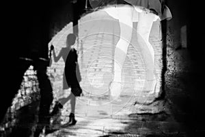 Silhouette of a woman in a dark alley of the city