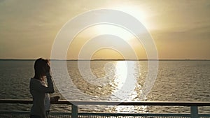 Silhouette of woman on deck of cruise ship at sunrise