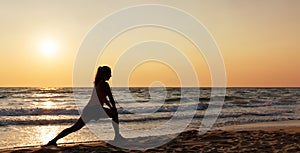 Silhouette of woman doing exercise on the beach