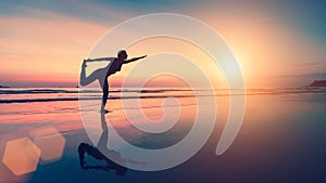 Silhouette of woman doing exercises on the sea beach