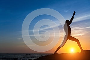 Silhouette woman doing fitness exercise on the sea beach