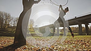 Silhouette of woman doing some acrobatic elements on aerial hoop outdoors