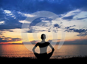 Silhouette of a woman doing yoga on a sunset