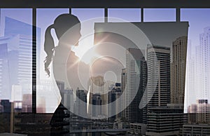 Silhouette of woman with flipboard over city