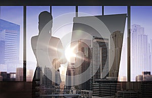 Silhouette of woman with flipboard over city