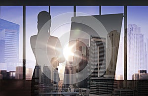 Silhouette of woman with flipboard over city photo
