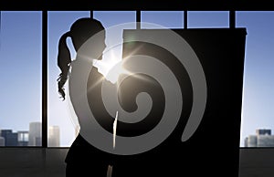 Silhouette of woman with flipboard over office