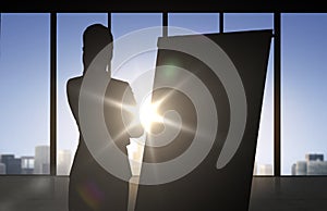 Silhouette of woman with flipboard over office photo