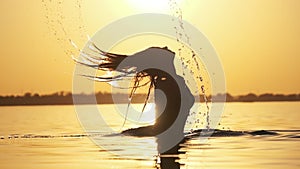 Silhouette of Woman Flipping Her Long Hair Back in Water. Slow Motion 240 fps