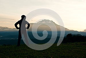 Silhouette of a woman getting ready to exercise with Mount kinabalu as background