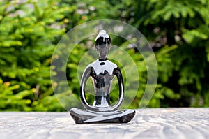Silhouette of woman or girl practicing yoga, meditate and pray on wooden surface