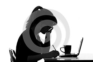 Silhouette of a woman in glasses working in the Internet