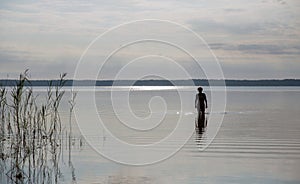 Silhouette of a woman going to swim in the lake