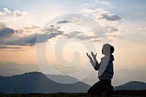 Silhouette of a woman with hands raised in the sunset concept for religion, worship, prayer and praise, Religious concepts