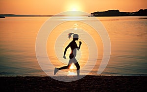 Silhouette woman jogging on beach