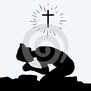 Silhouette of a woman kneeling in prayer