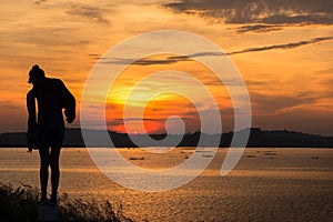 Silhouette of woman at lake ,sunrise background