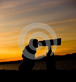 Silhouette of Woman Looking Through Telescope