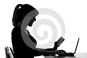 Silhouette of a woman makes online purchase at home