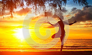 Silhouette of woman meditating on the beach. Yoga.
