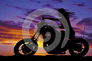 Silhouette of a woman on a motorcycle wind blowing