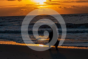 Silhouette of a woman on Orange beach in Alabama, USA during sunset