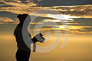 Silhouette of a woman photographer standing