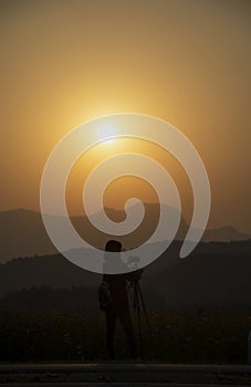 Silhouette woman photographer at sunset, person taking a photo landscape at the high mountain