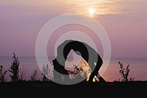 Silhouette of the woman practicing yoga