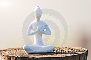 Silhouette of woman practicing yoga and meditate on the wooden surface at sunset