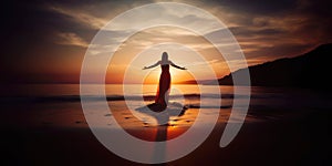 Silhouette of a woman practicing yoga or meditating on the beach at sunrise. Yoga concept