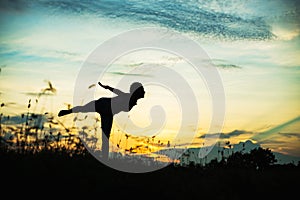 Silhouette of woman praying over beautiful sky background