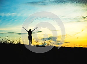 Silhouette of woman praying over beautiful sky background