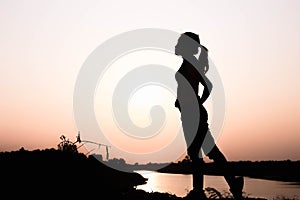 Silhouette of woman praying over beautiful sky background