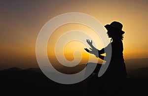 silhouette of woman praying to god Highest faith in religion and belief in God based on prayer. The power of hope or love and