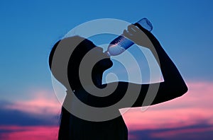 Silhouette of woman Rehydrate and refresh at sunset