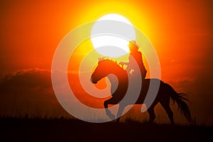 Silhouette of a woman riding a horse Running into the sunset and the sun is directly behind the figure