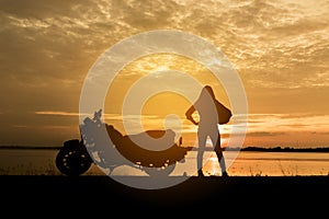 Silhouette woman riding motor bike with sunset