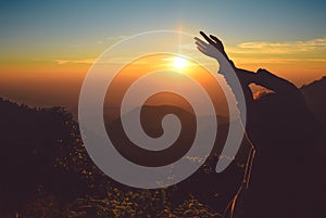 Silhouette woman rising hands on mountain in morning with vintage light,North Thailand