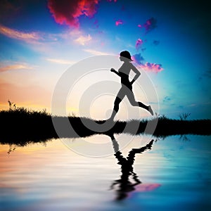 Silhouette of woman running at sunset