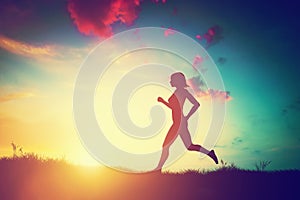 Silhouette of woman running at sunset